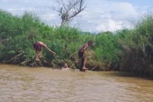 Boys practice their dives wearing longyis