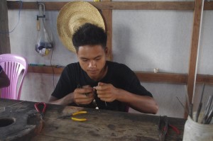 Boy making fish earings